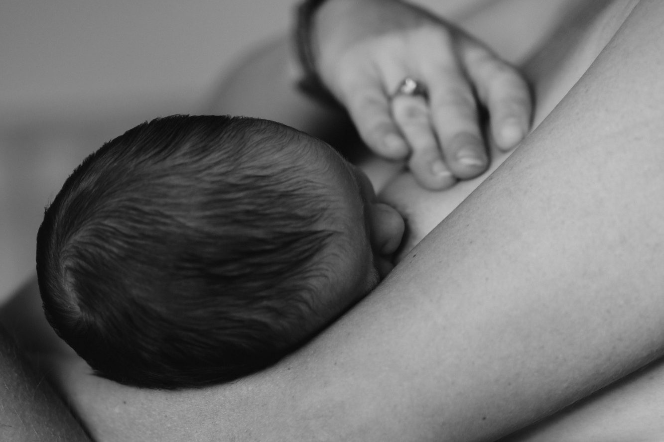 Ein Baby stillt an einer Brust.